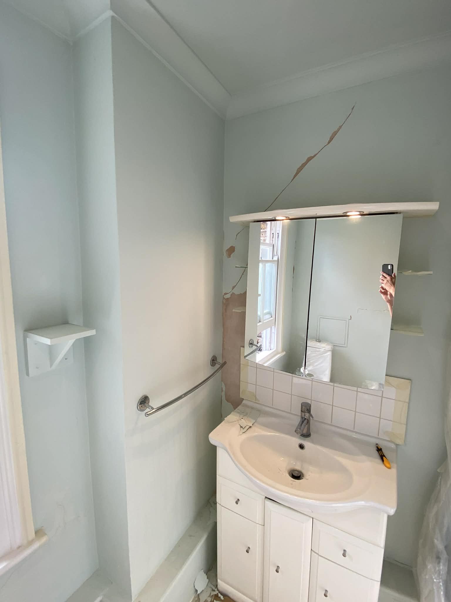 Bathroom walls with damaged and peeling paint before renovation