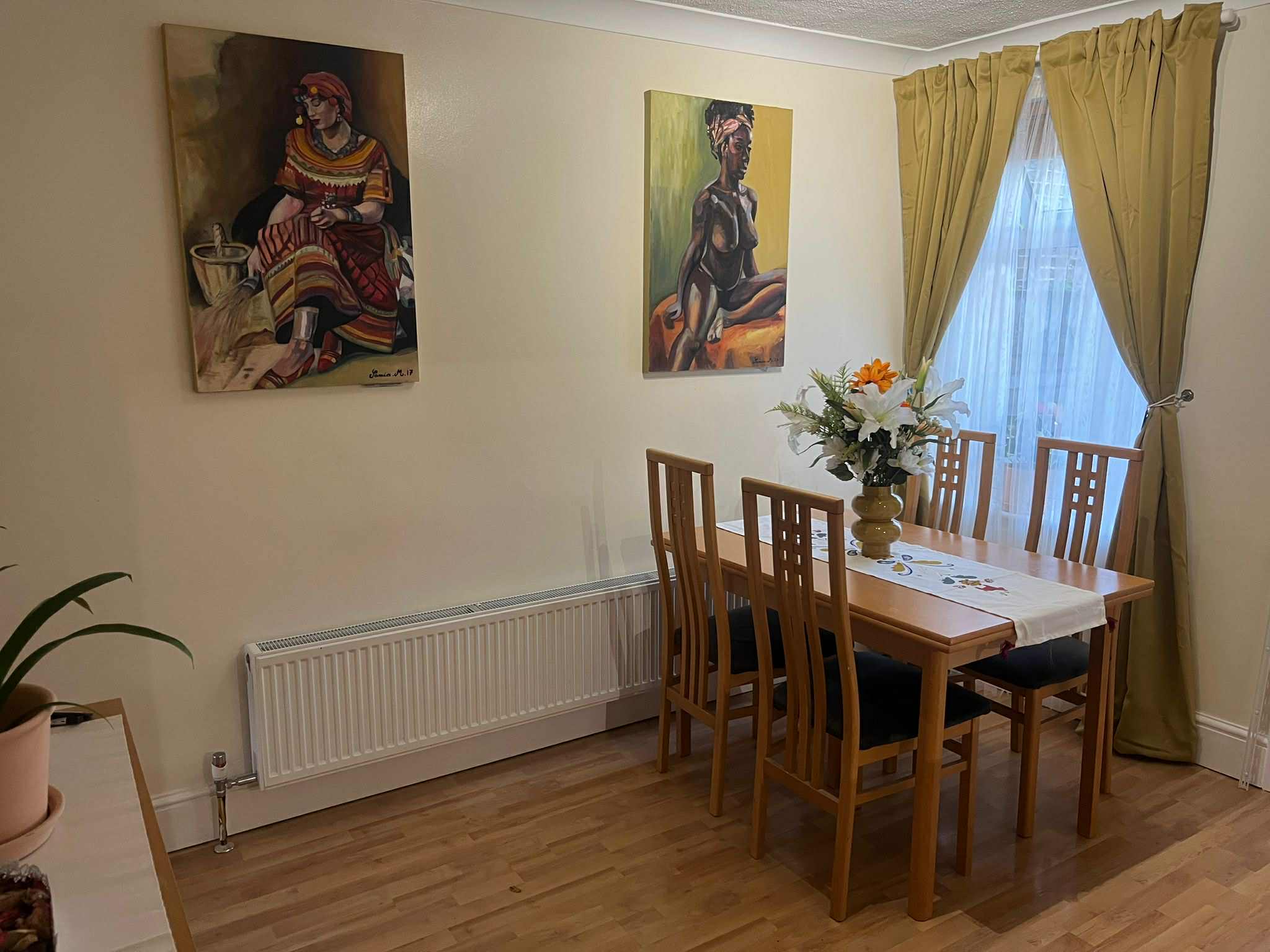 Finished dining room with neutral walls, artwork and warm curtains