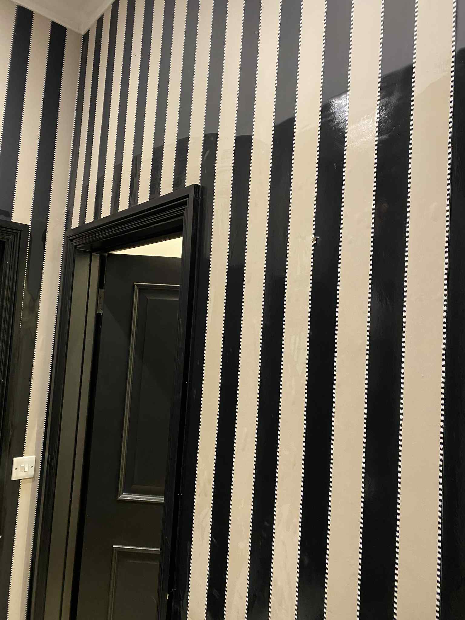 London hallway with black and white striped wallpaper before decorating